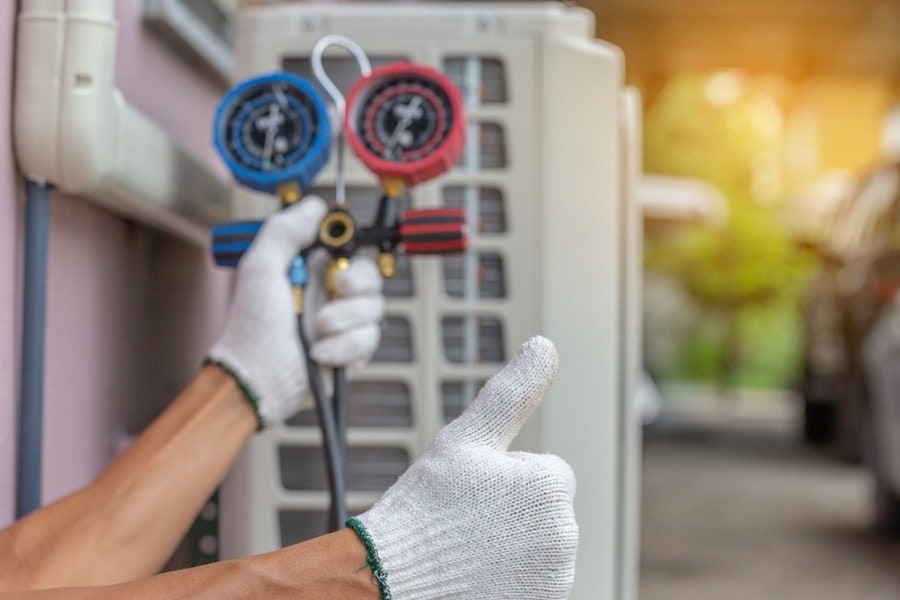 repairman on the floor fixing air conditioning system